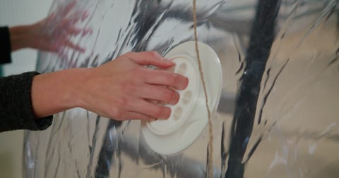 Person holding a round white object on an installation.