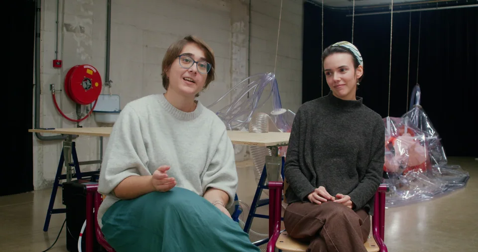 Two women sitting in front of a table.