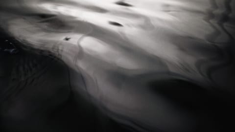 This is a blurry image with dark and light swirls, evoking the impression of water.