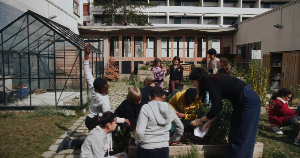 Group of people around a small garden area.