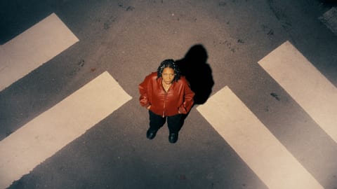 Image of a person standing in the middle of a crosswalk at night.
